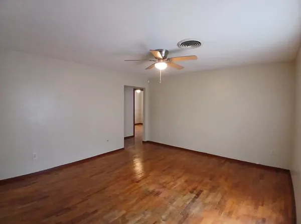 a view of an empty room with wooden floor