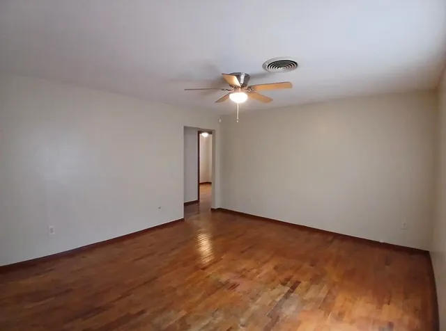 a view of an empty room with wooden floor
