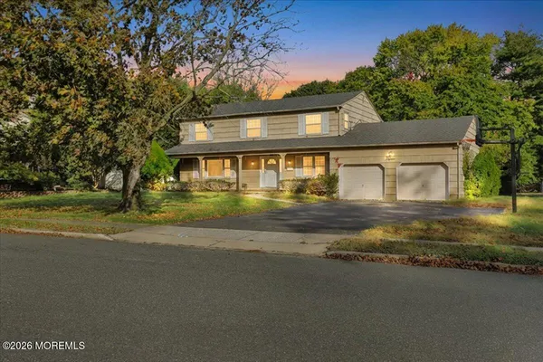 a front view of a house with a yard and lake view