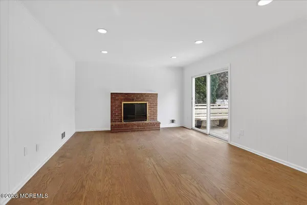 an empty room with floor to ceiling window and fireplace