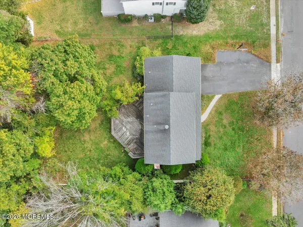 an aerial view of a house with a yard and a large tree