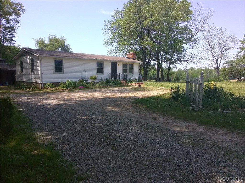 a view of a yard in front of a house with large trees