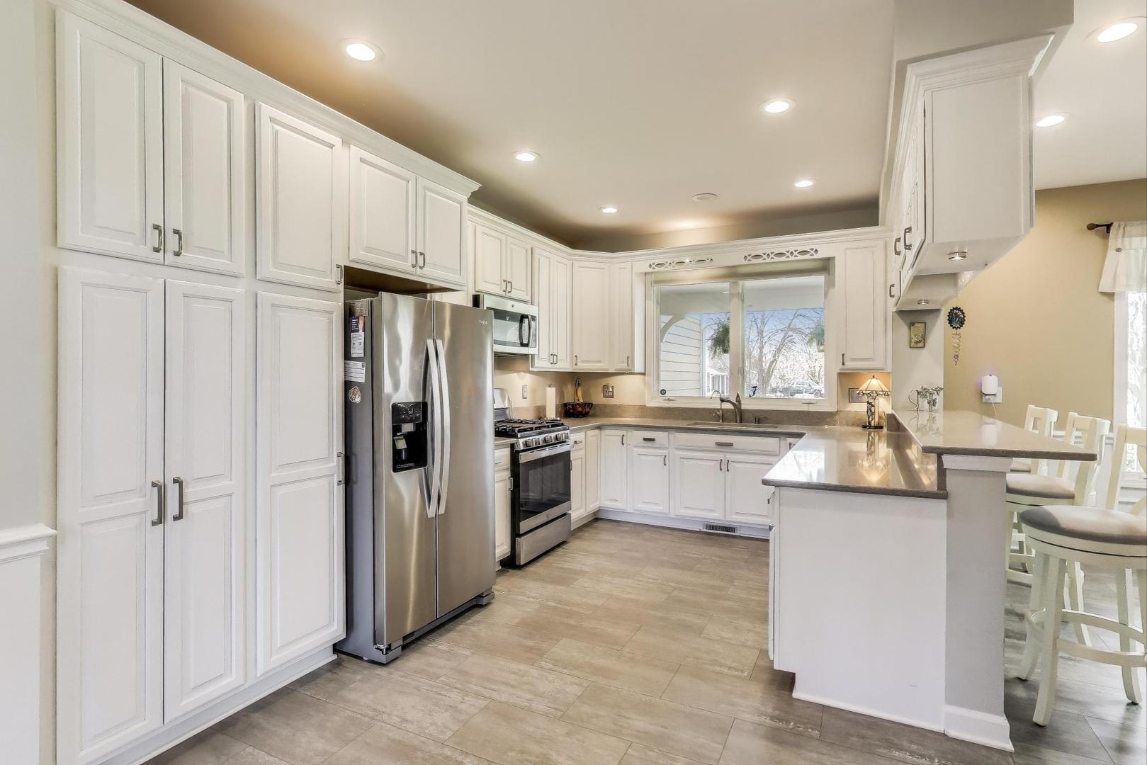 2502 Hidden Trail Spring Grove, IL 60081 - Photo 11 of 51 a kitchen with white cabinets and stainless steel appliances