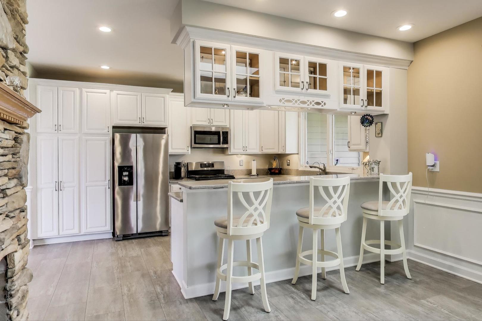 2502 Hidden Trail Spring Grove, IL 60081 - Photo 12 of 51 a kitchen with white cabinets and stainless steel appliances