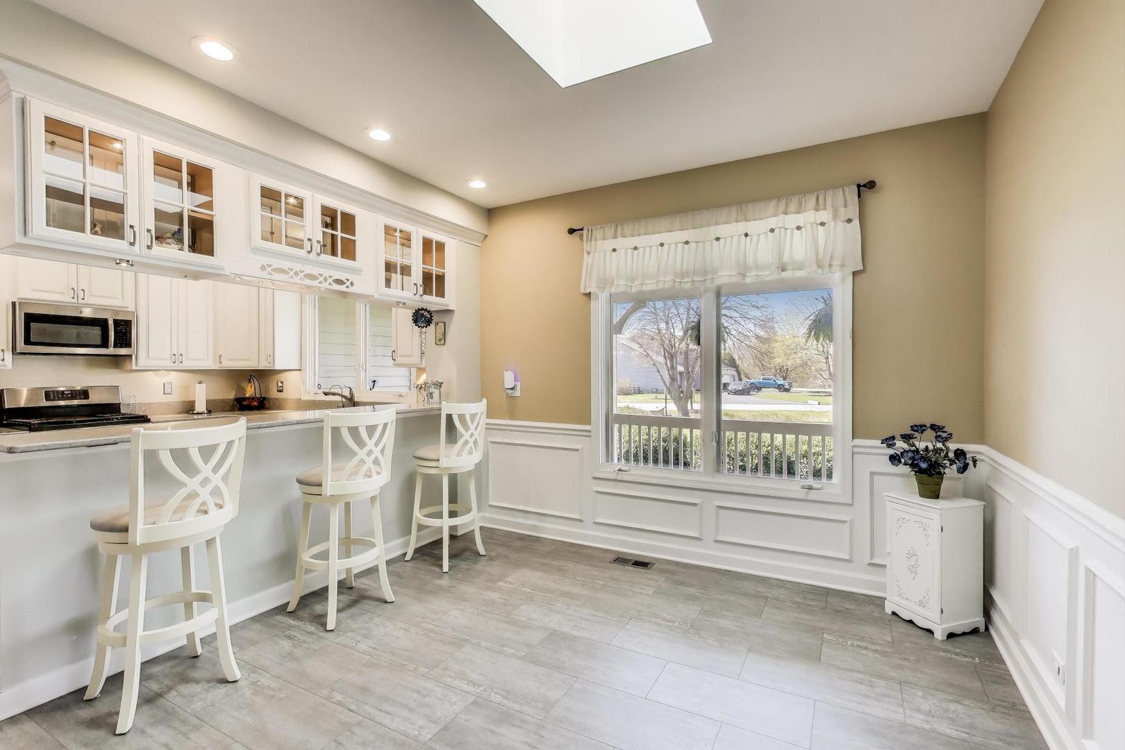 2502 Hidden Trail Spring Grove, IL 60081 - Photo 13 of 51 a kitchen with white cabinets and window