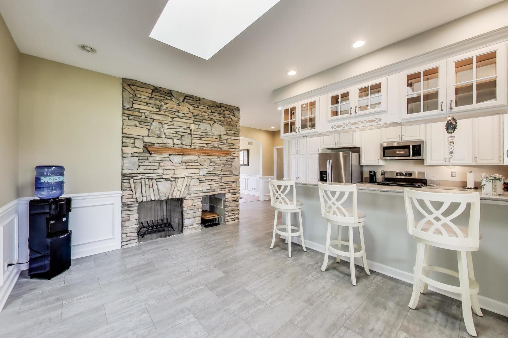 2502 Hidden Trail Spring Grove, IL 60081 - Photo 15 of 51 a living room with furniture a fireplace and kitchen view