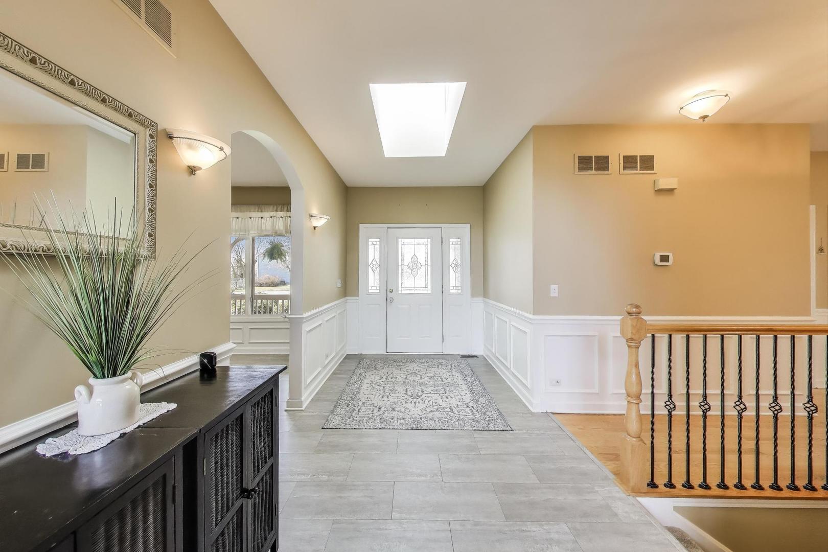 2502 Hidden Trail Spring Grove, IL 60081 - Photo 6 of 51 a view of a hallway with wooden floor and a bathroom