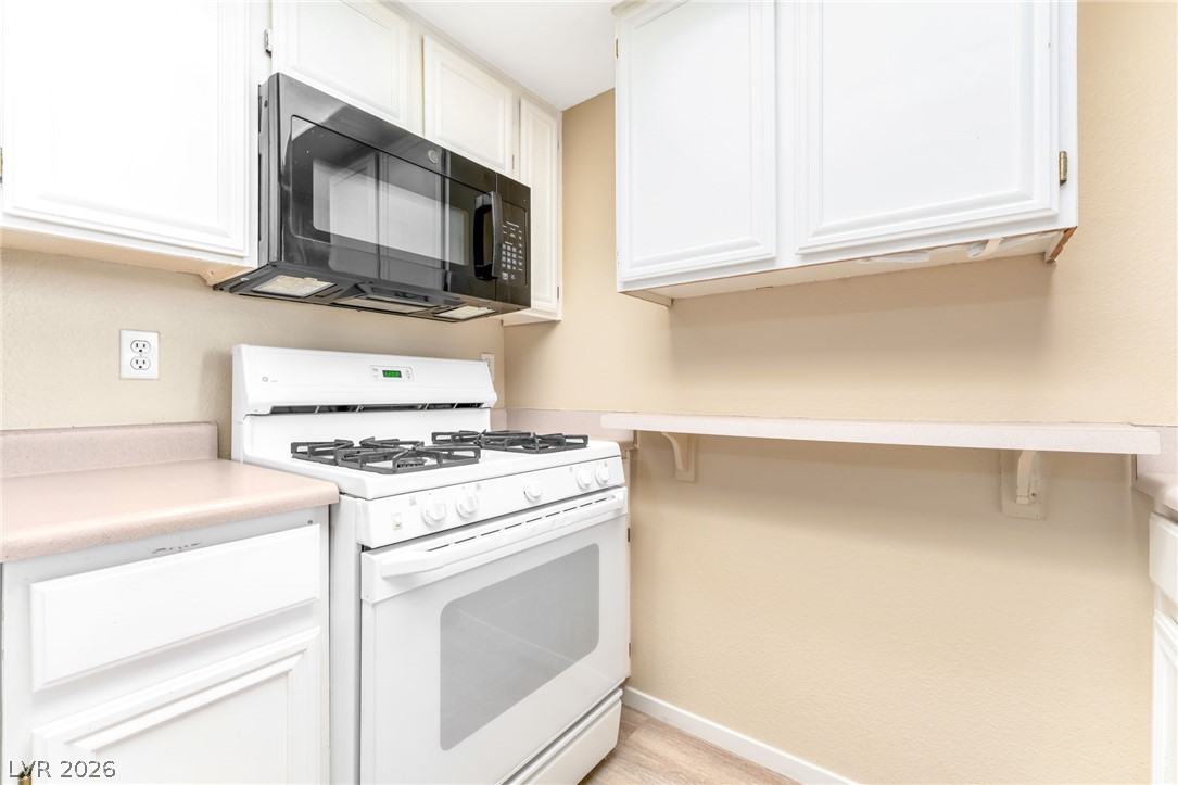 8070 West Russell Road, Unit 1054 Las Vegas, NV 89113 - Photo 9 of 22 Streamlined kitchen featuring a built-in microwave and gas range for effortless meal preparation.