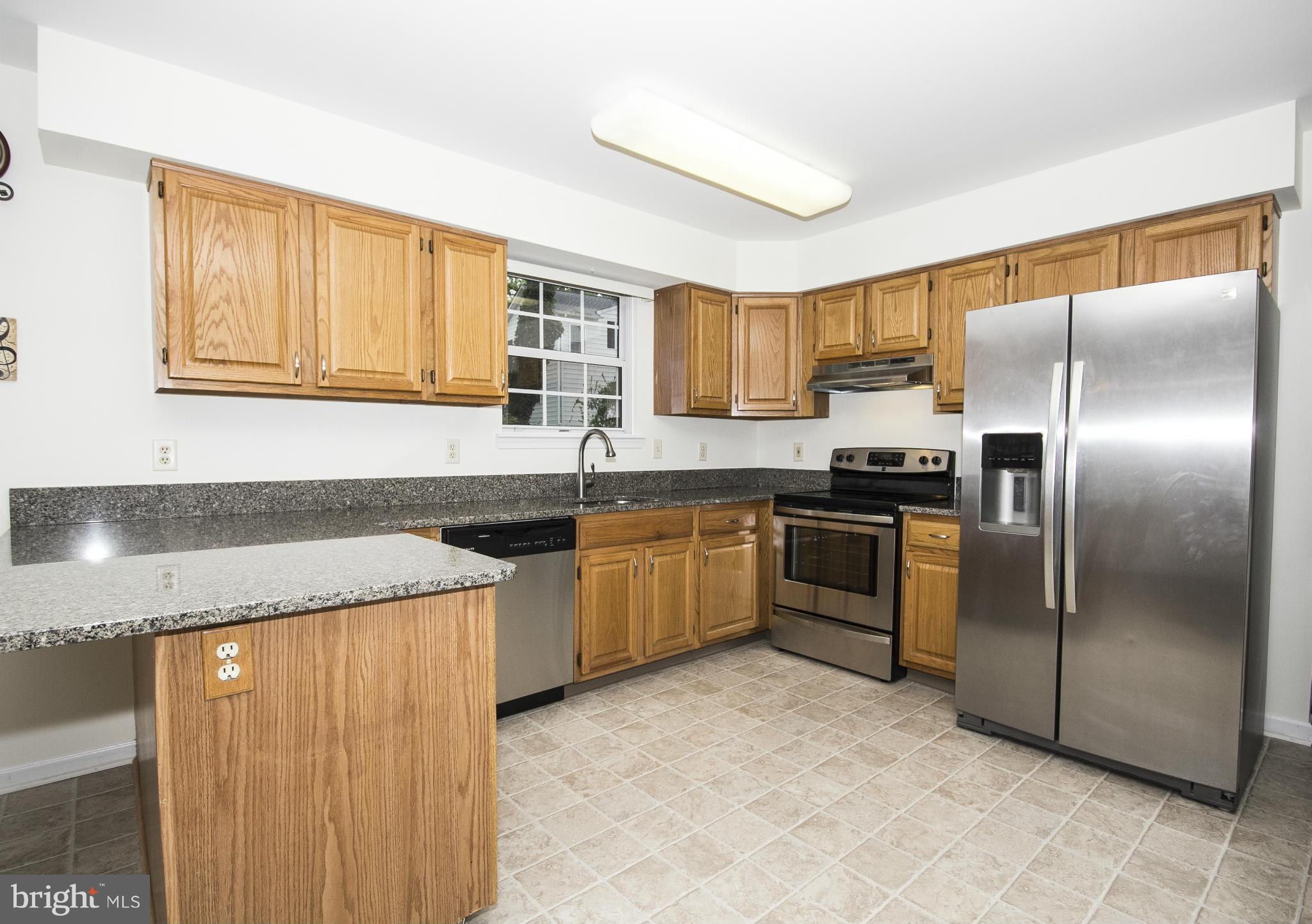 4309 Mispillion Road Baltimore, MD 21236 - Photo 8 of 29 a kitchen with a refrigerator sink and cabinets
