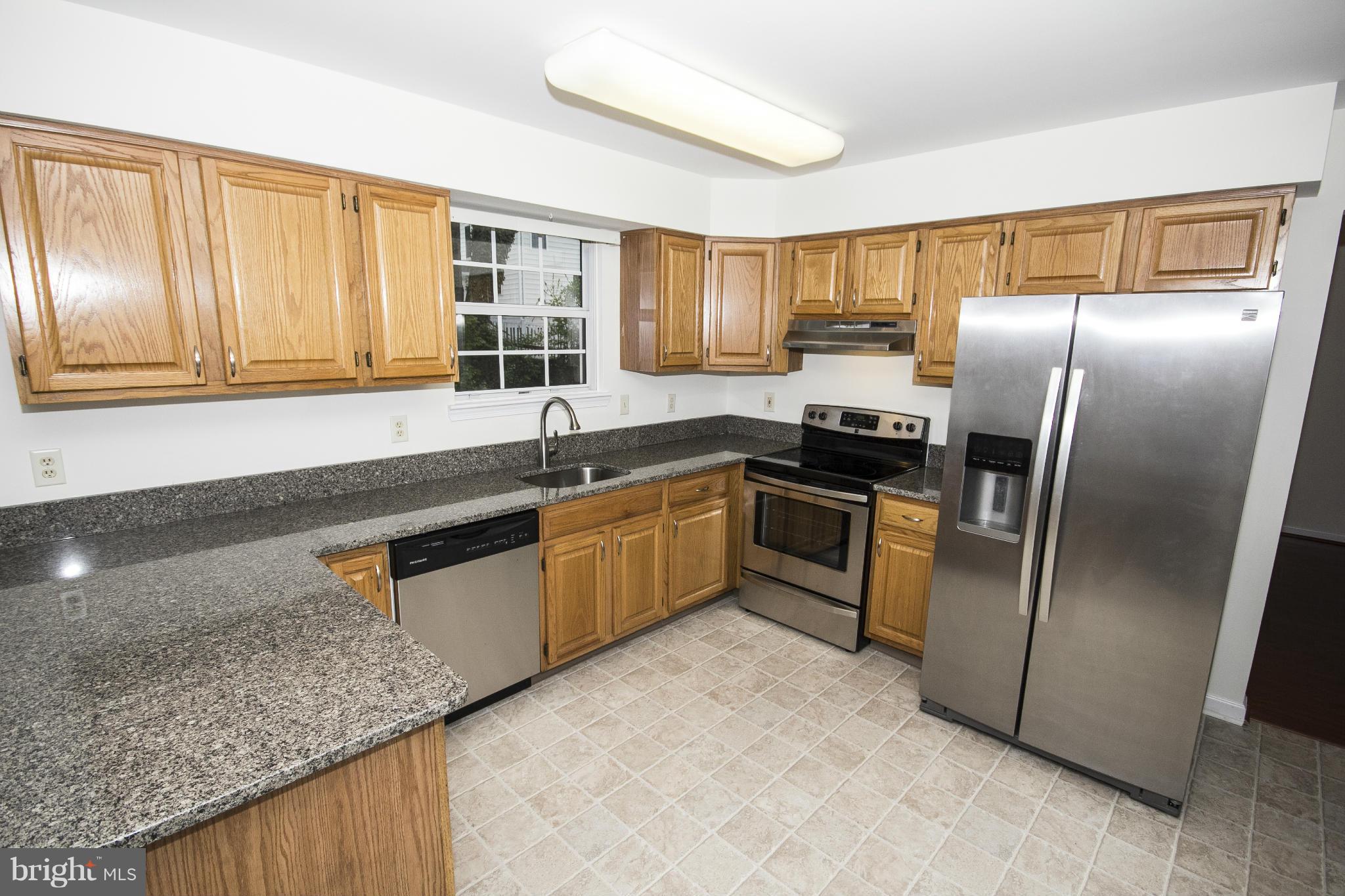4309 Mispillion Road Baltimore, MD 21236 - Photo 9 of 29 a kitchen with a refrigerator sink and cabinets