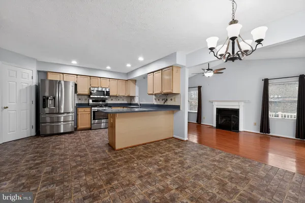 a kitchen with stainless steel appliances granite countertop a refrigerator and a stove top oven