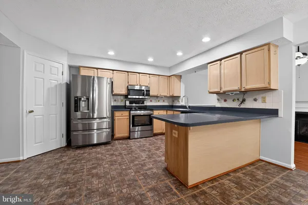 a kitchen with stainless steel appliances granite countertop a refrigerator stove and sink