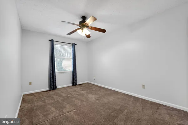 a view of a room with a ceiling fan and a window