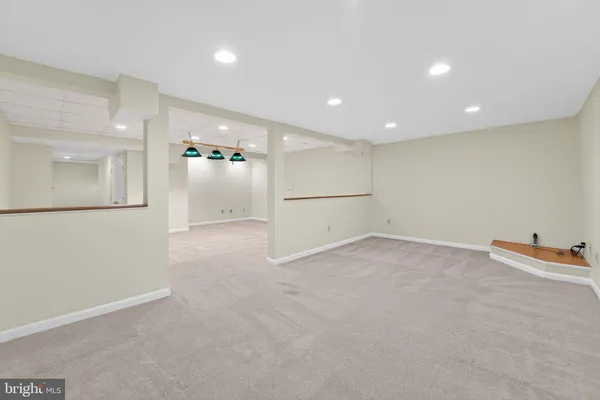 an empty room with an entryway and a refrigerator