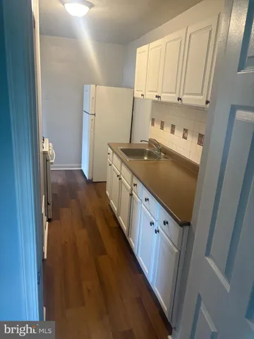 a kitchen with white cabinets and white appliances