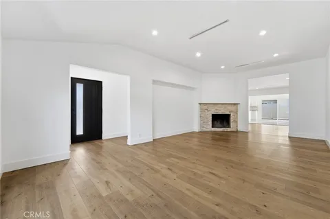 an empty room with wooden floor and fireplace