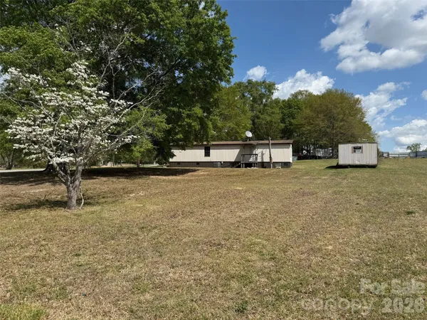 a view of a yard with wooden fence