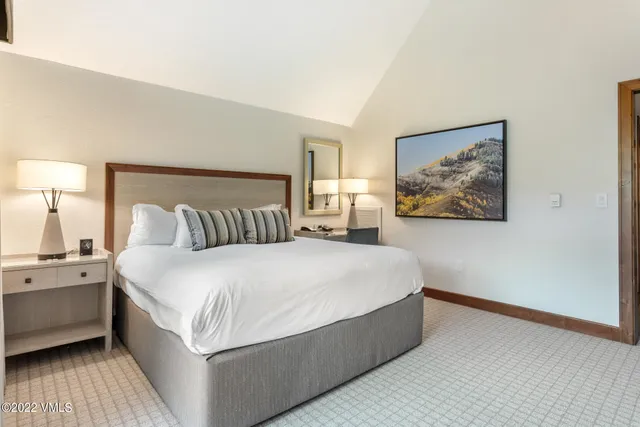 a spacious bedroom with a bed and a night stand