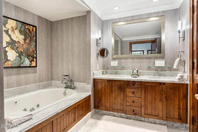 a bathroom with a granite countertop tub sink and mirror