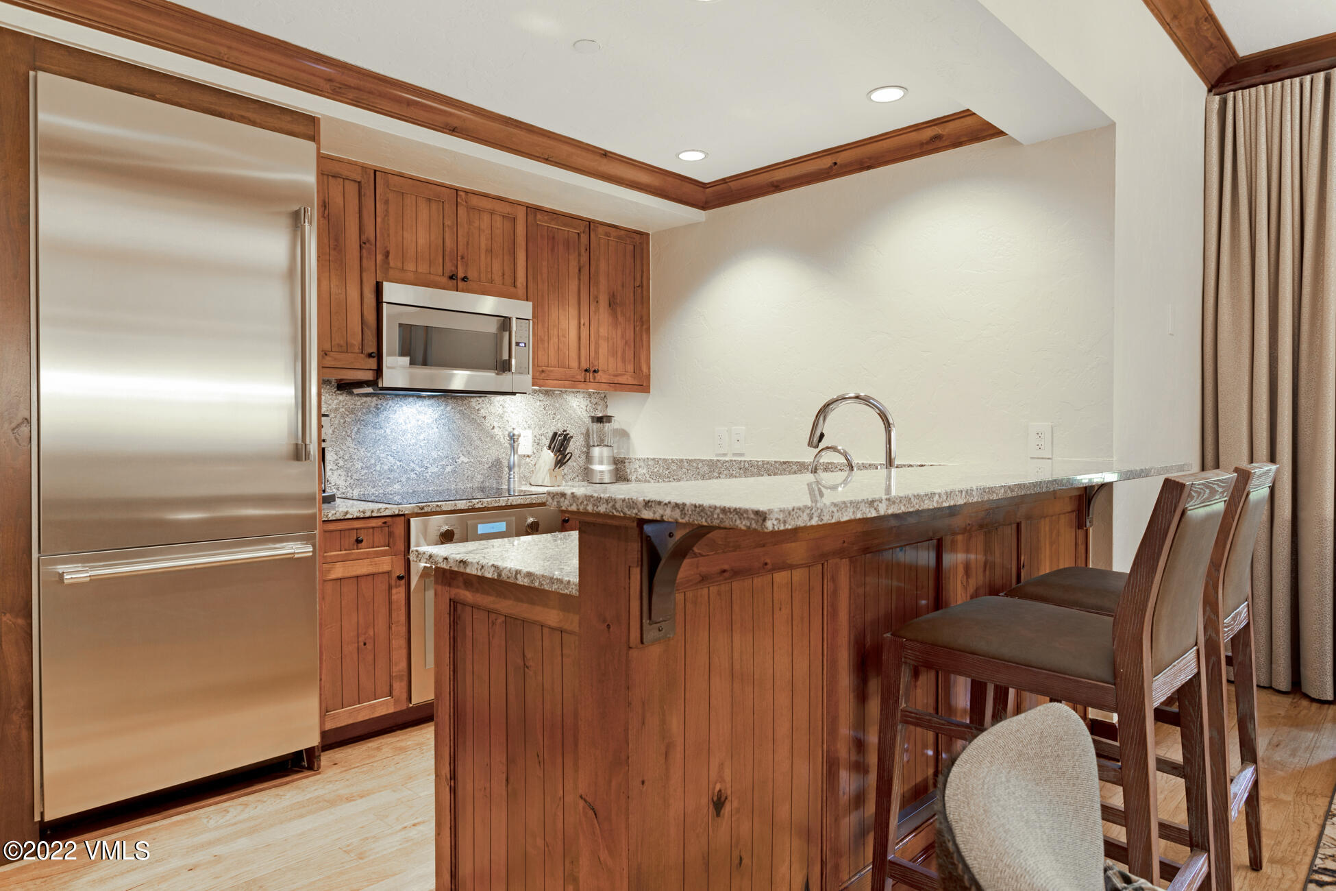 100 Bachelor Ridge Road, Unit 3704 Avon, CO 81620 - Photo 5 of 41 a kitchen with granite countertop a refrigerator and a stove top oven
