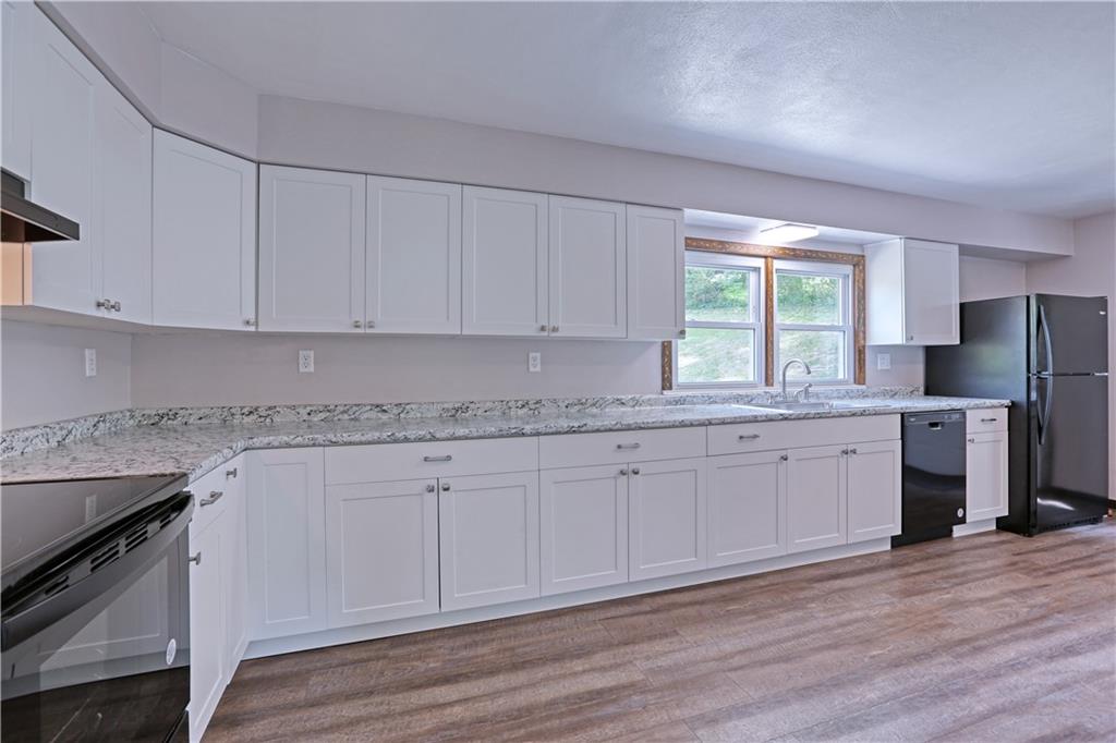 123 Noonen Street Rochester, PA 15074 - Photo 12 of 34 a kitchen with granite countertop white cabinets stainless steel appliances a sink and wooden floor