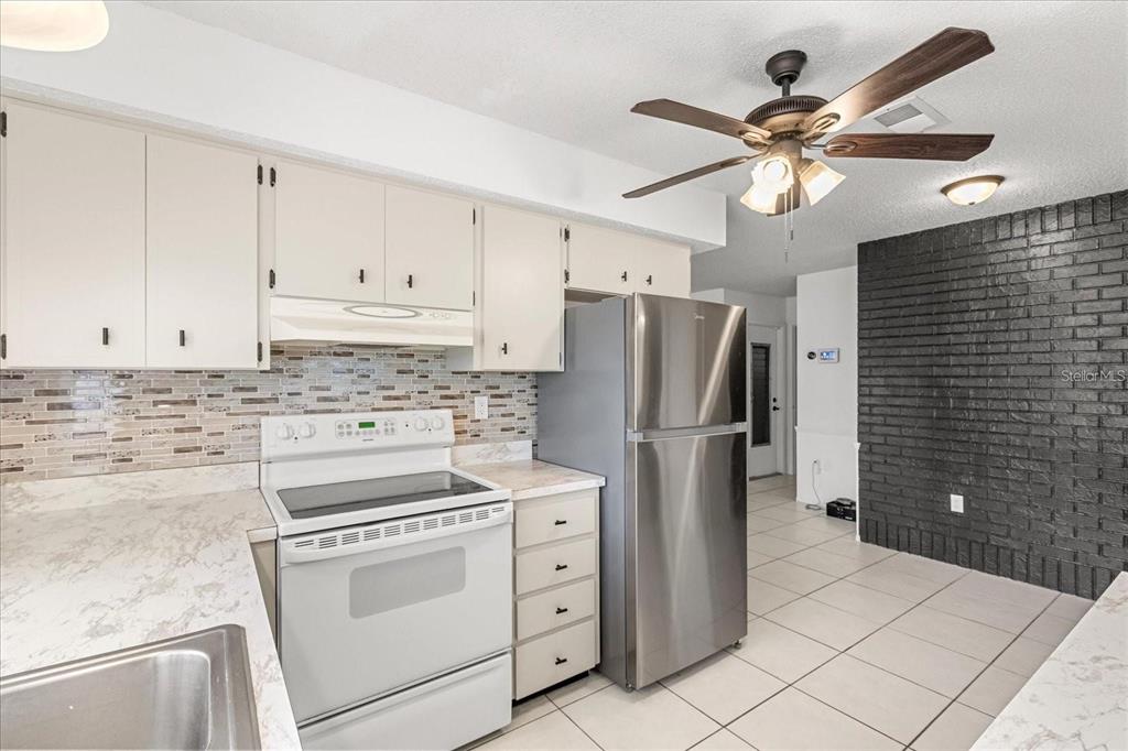 13013 Sawmill Way Hudson, FL 34667 - Photo 12 of 33 a kitchen with cabinets stainless steel appliances and a counter top space