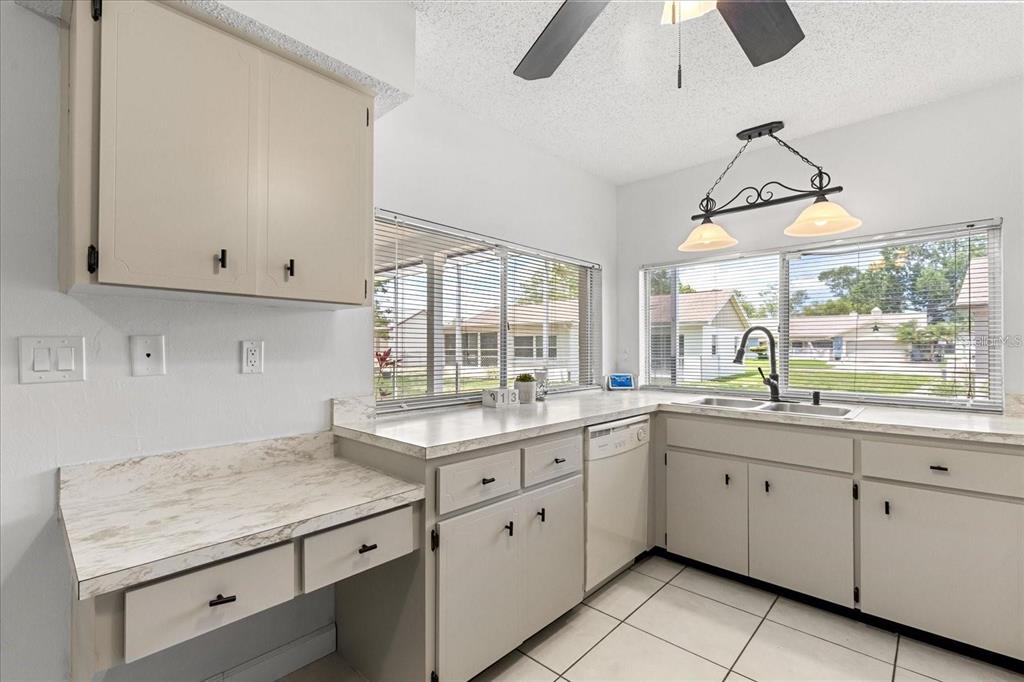 13013 Sawmill Way Hudson, FL 34667 - Photo 18 of 33 a kitchen with white cabinets and window