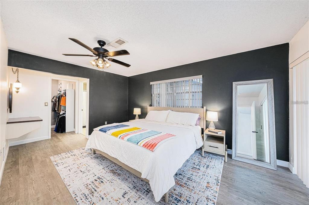 13013 Sawmill Way Hudson, FL 34667 - Photo 22 of 33 a bedroom with a bed and a chandelier