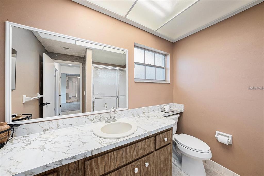 13013 Sawmill Way Hudson, FL 34667 - Photo 26 of 33 a bathroom with a granite countertop sink a toilet and a mirror
