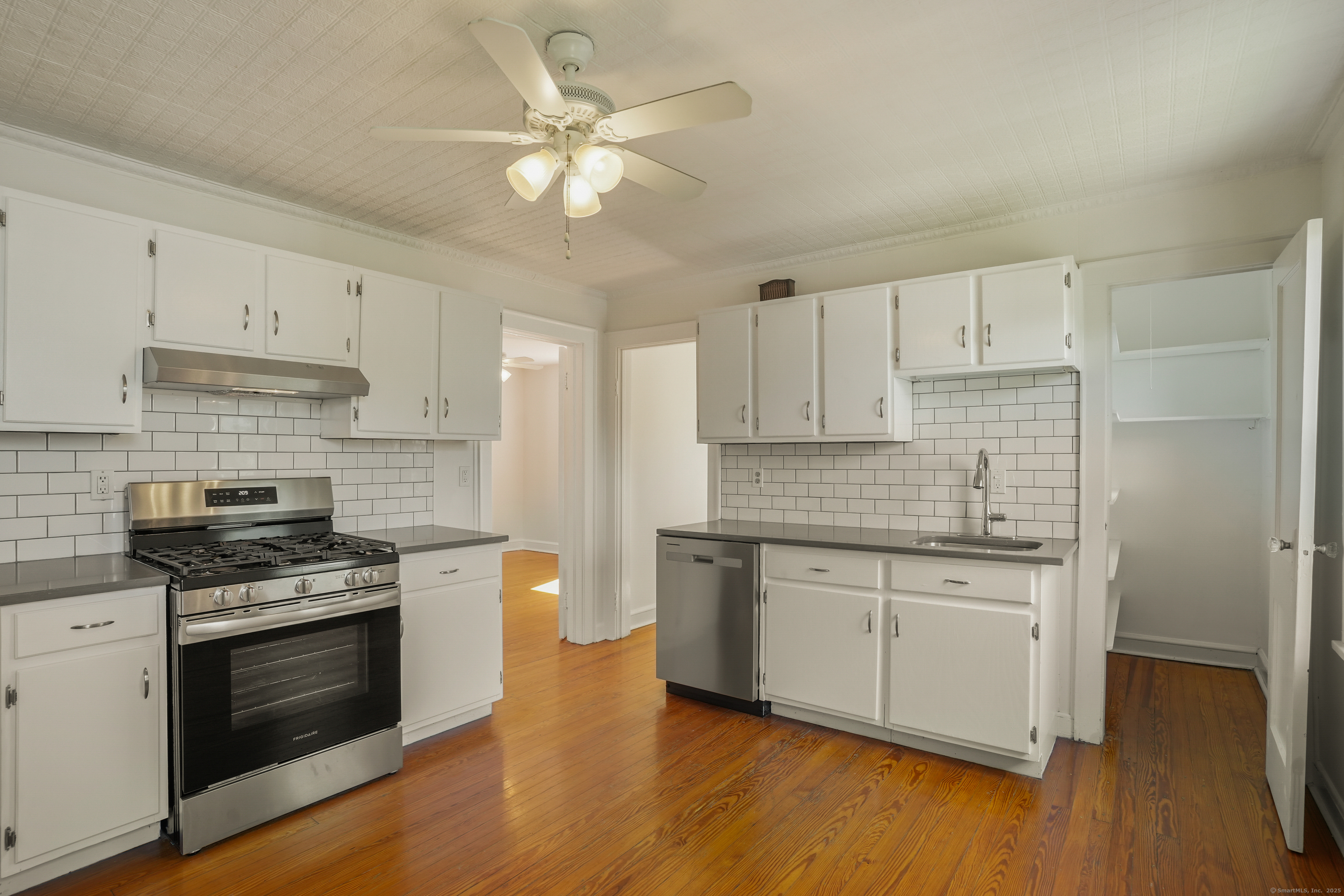 221 Hunyadi Avenue Fairfield, CT 06824 - Photo 31 of 39 a kitchen with stainless steel appliances a stove a sink and white cabinets