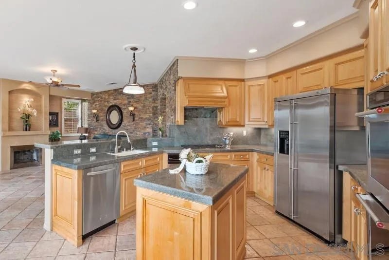 3674 Via Calabria Escondido, CA 92025 - Photo 15 of 49 a kitchen with stainless steel appliances granite countertop a sink and a refrigerator