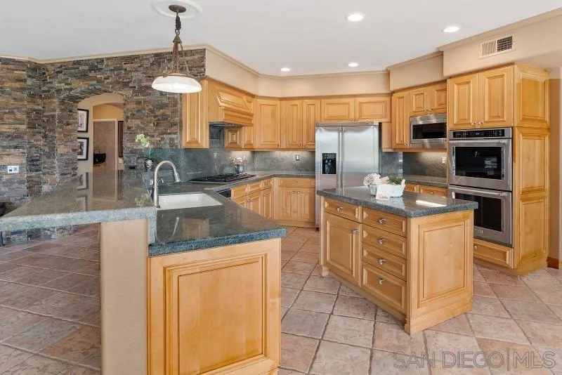 3674 Via Calabria Escondido, CA 92025 - Photo 16 of 49 a kitchen with stainless steel appliances granite countertop a sink stove and refrigerator