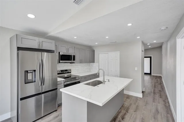 a kitchen with a sink stainless steel appliances and refrigerator