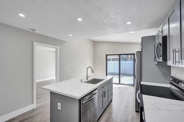 a kitchen with granite countertop a sink and a refrigerator