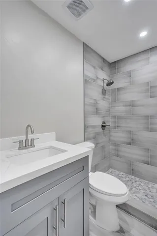 a bathroom with a sink a toilet and shower