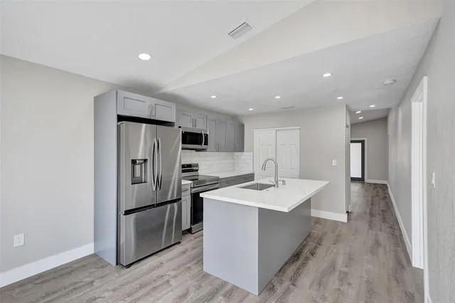 a kitchen with stainless steel appliances a sink stove and refrigerator