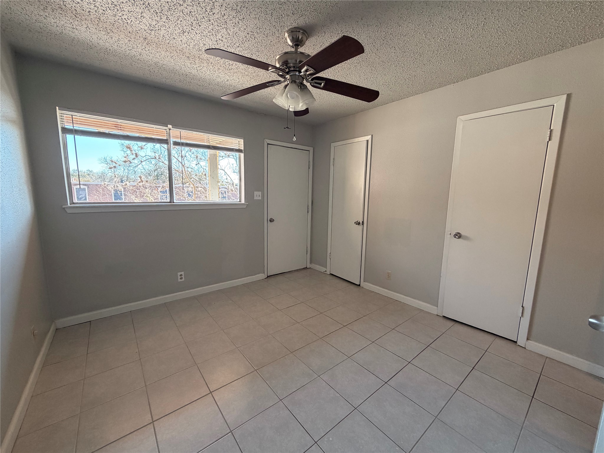 4303 Duval Street, Unit 204 Austin, TX 78751 - Photo 8 of 14 an empty room with fan and windows