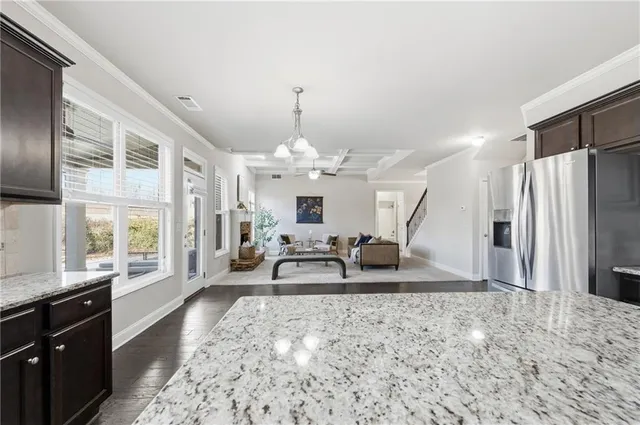 a kitchen with stainless steel appliances granite countertop a stove a sink dishwasher a microwave oven and a refrigerator with wooden cabinets