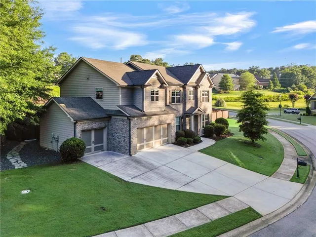 a front view of a house with a garden and plants