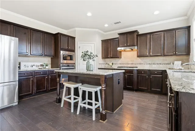 a bathroom with a granite countertop sink and a large mirror