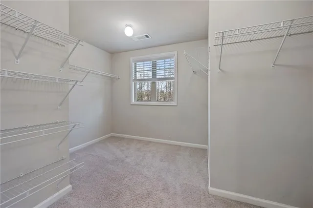 a view of an empty room and chandelier fan