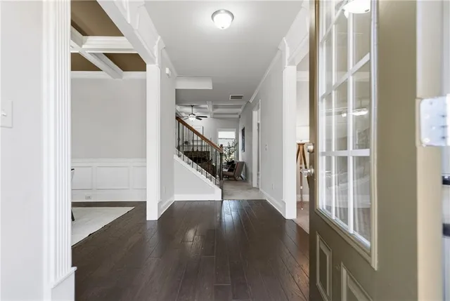 a dining room with chandelier and wooden floor