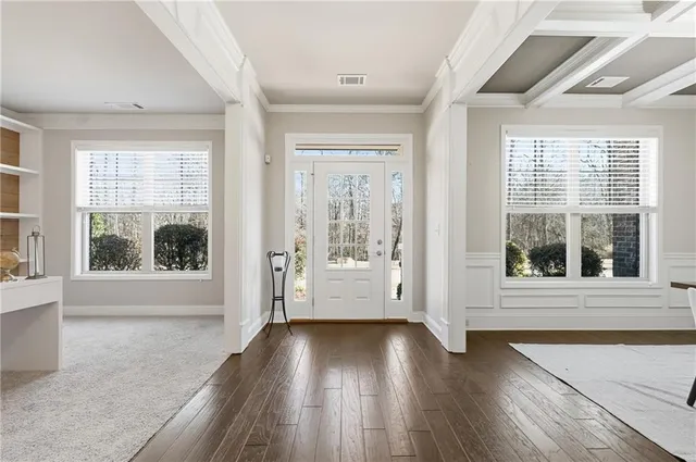 a dining room with wooden floor a chandelier a wooden table and chairs