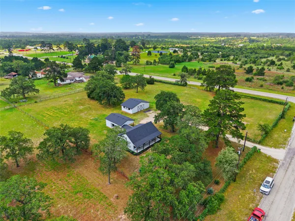 an aerial view of a houses with a yard and lake view