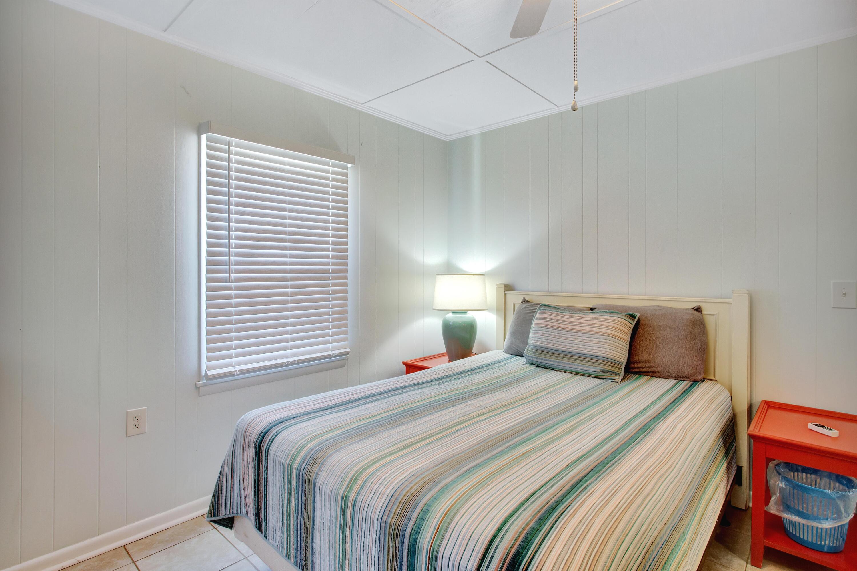 545 Blue Mountain Road Santa Rosa Beach, FL 32459 - Photo 13 of 27 a bedroom with a bed and a lamp on the dresser