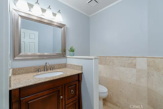 a bathroom with a granite countertop sink a toilet and a mirror