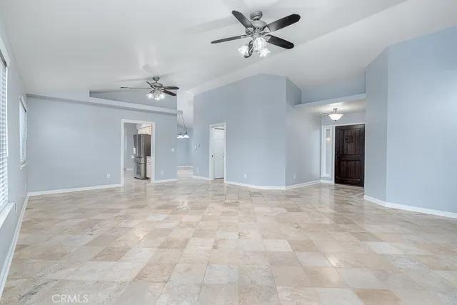 a view of an empty room and chandelier fan