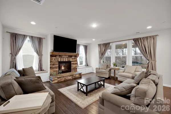 an open kitchen with kitchen island wooden floor and stainless steel appliances