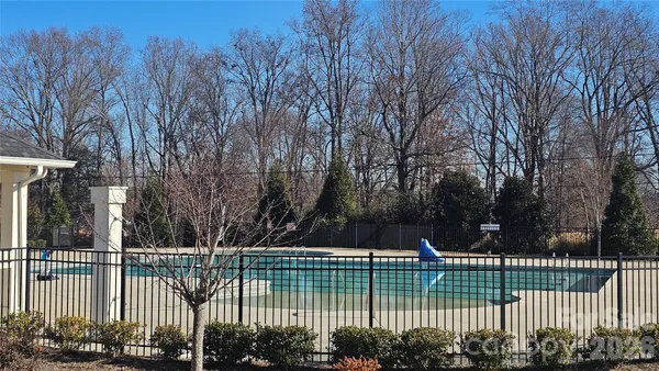 a view of swimming pool with outdoor seating and trees in the background