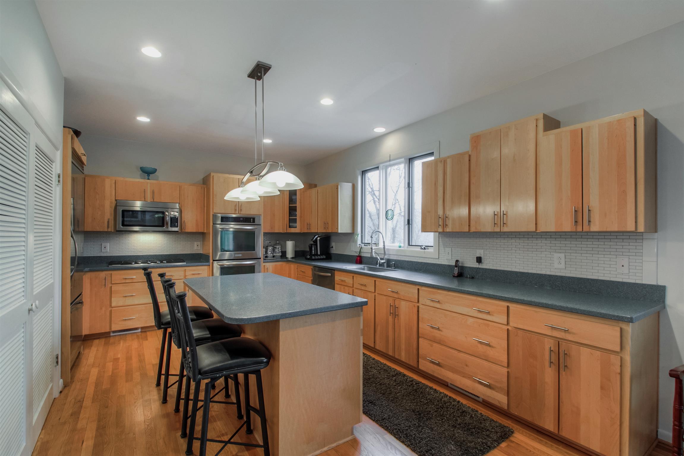 788 High Point Ridge Road Franklin, TN 37069 - Photo 19 of 30 a kitchen with stainless steel appliances granite countertop a sink a stove a dining table and chairs